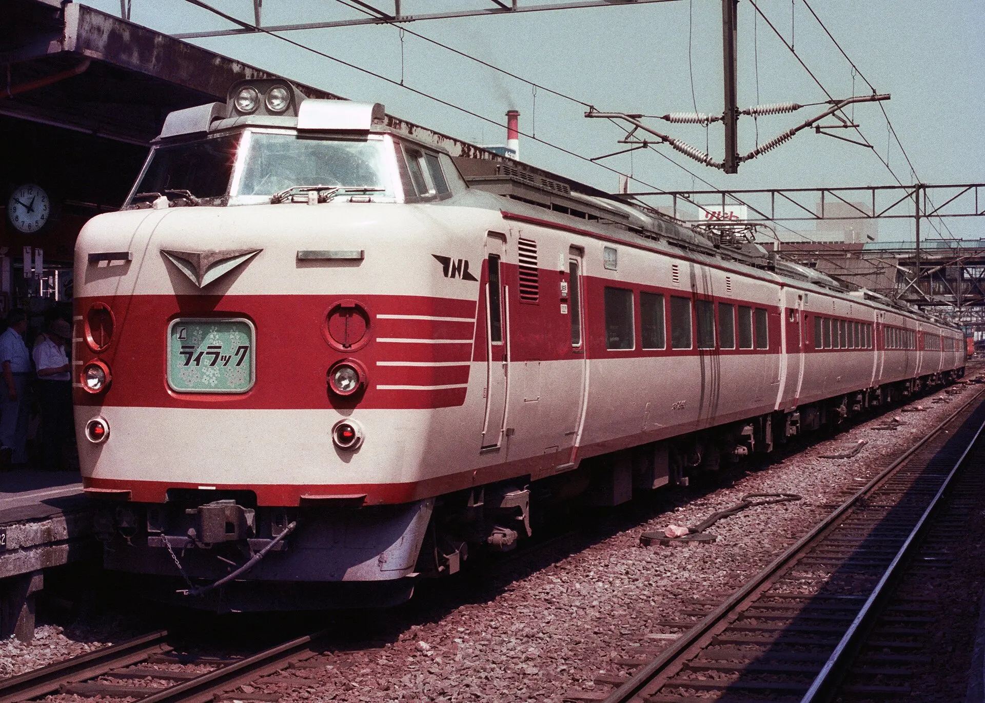 Red and cream JNR 781 series express train waiting at a station platform