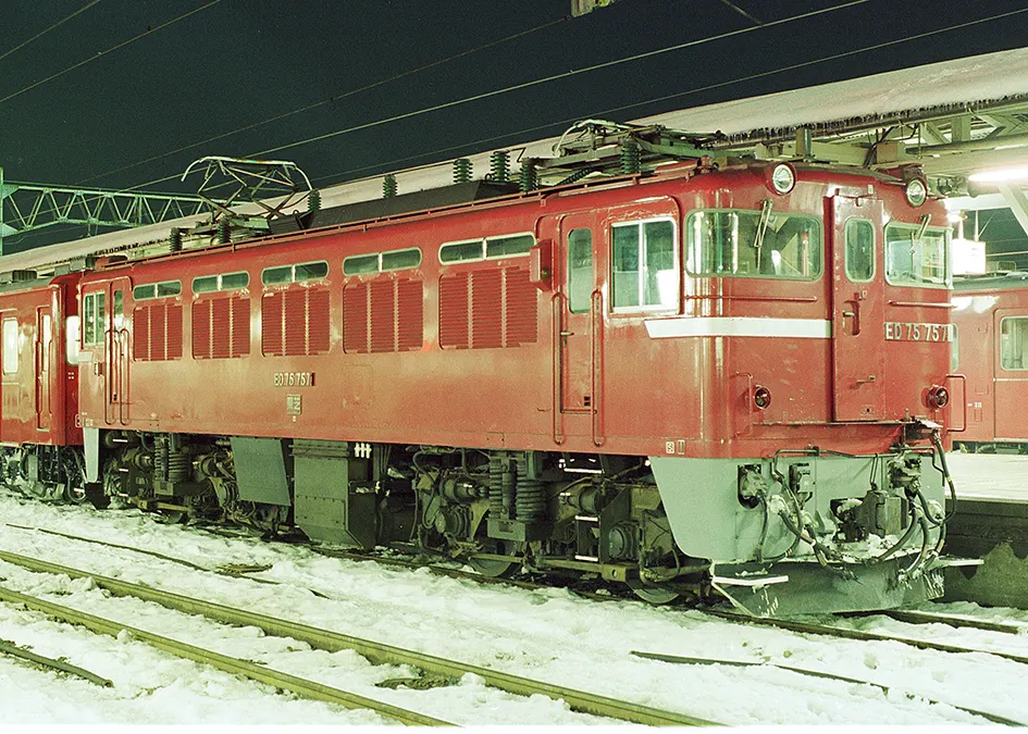Red electric locomotive ED75 757 standing in snow at a station