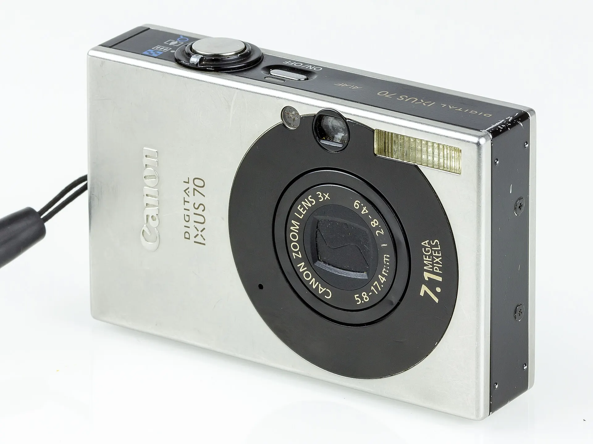 Silver Canon Digital IXUS 70, sold in the US as the PowerShot SD1000, seen from the front at an angle with its 3x zoom lens retracted
