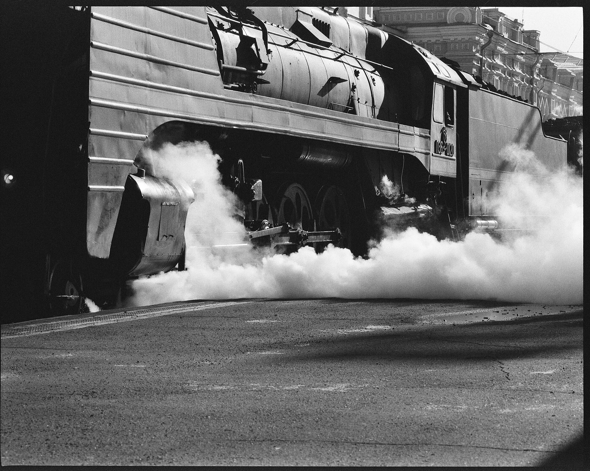 A steam locomotive pulling away in a cloud of white steam