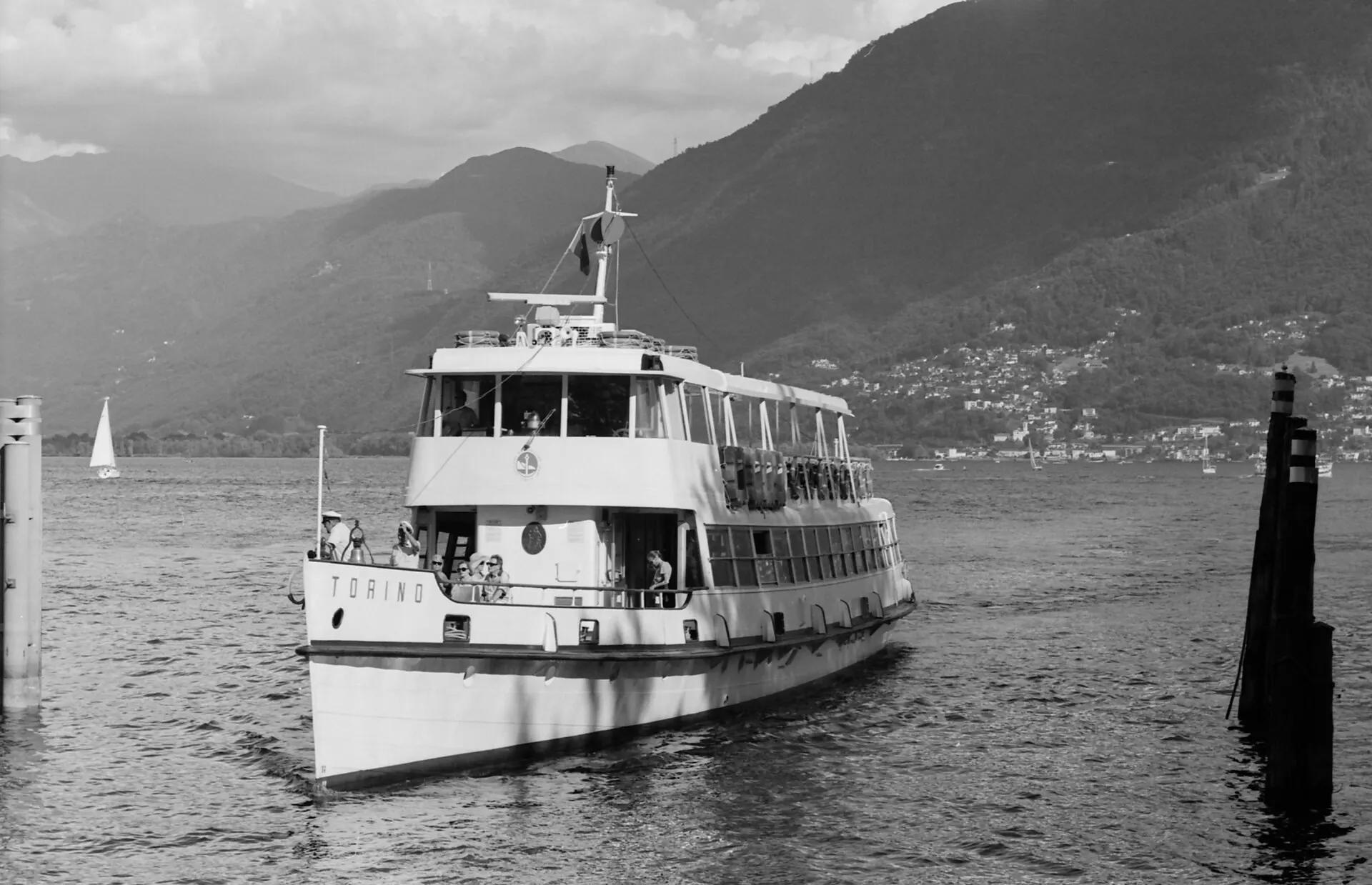 Lake ferry Torino approaching the pier with mountains behind