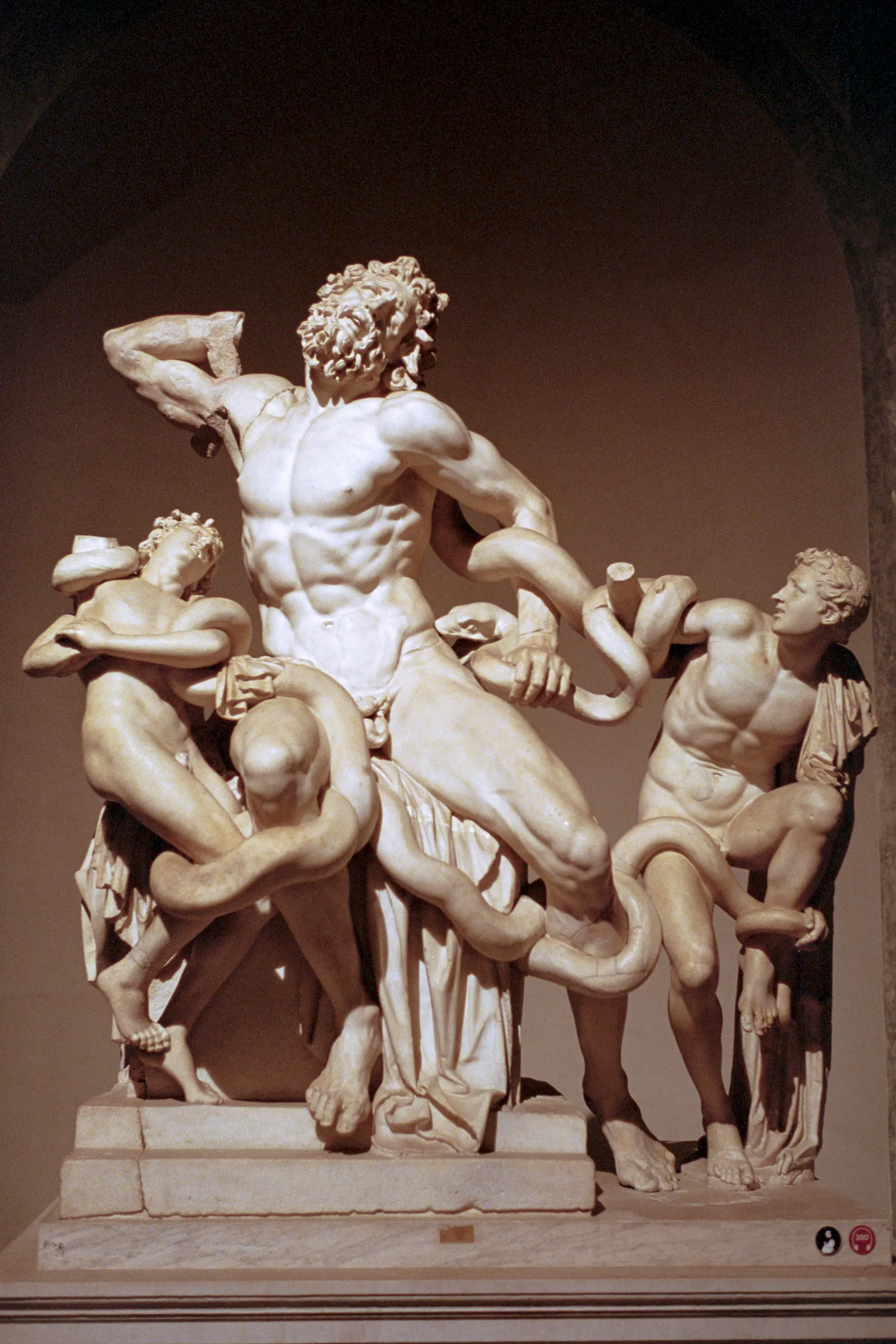The marble Laocoon statue group lit in a dark niche at night