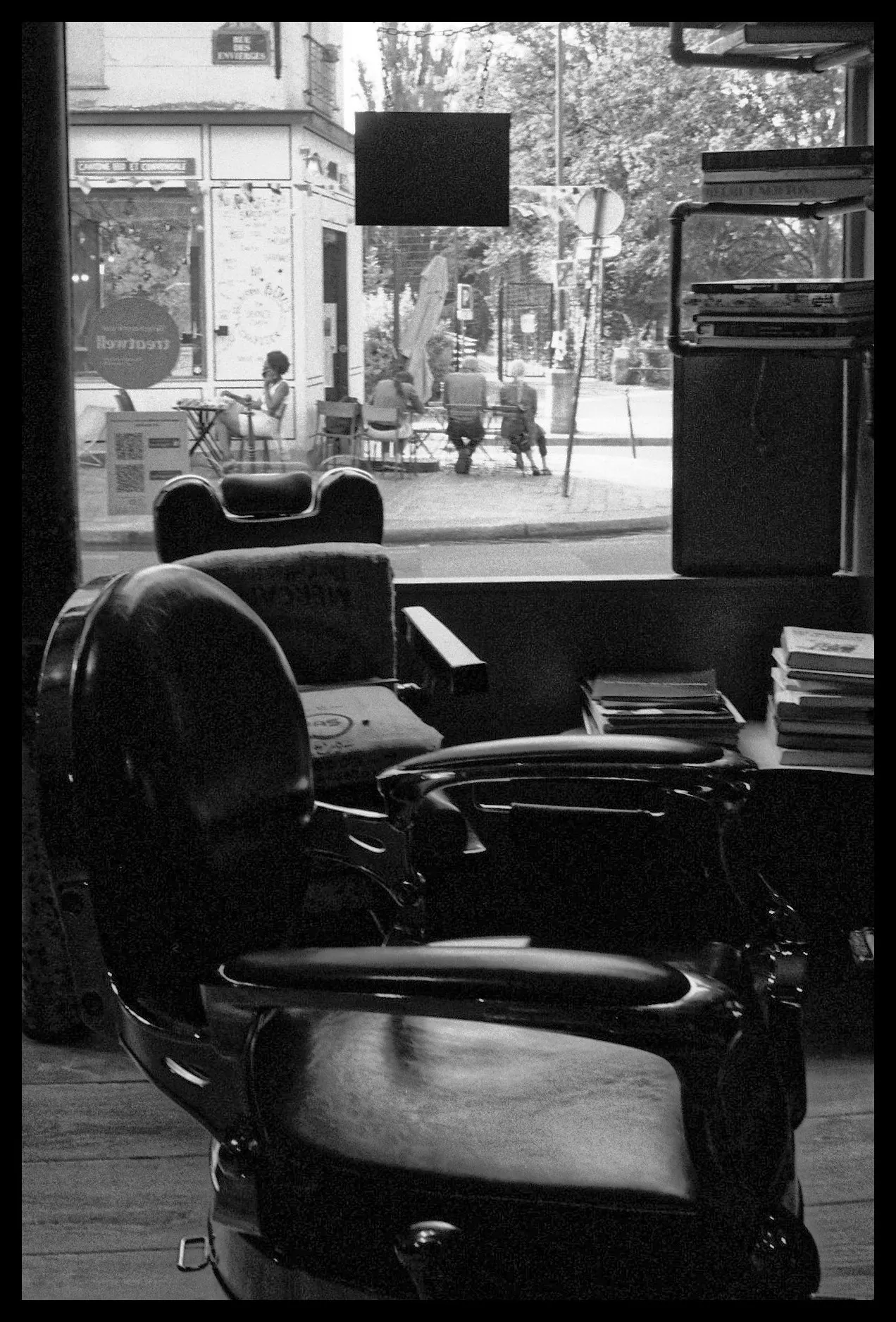 Empty barber chair facing a shop window, in black and white