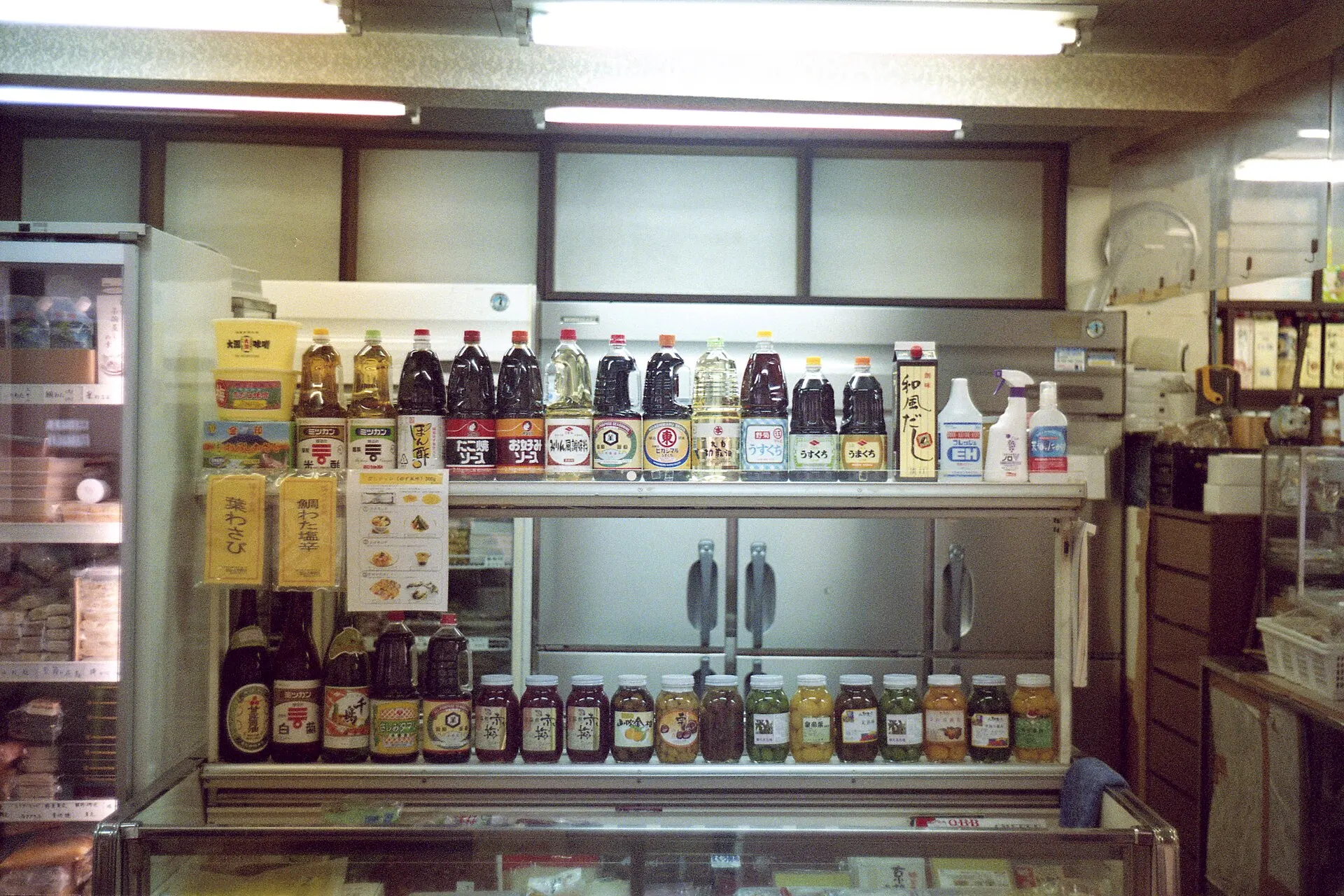 Shelves of bottles and a counter inside a covered market, shot on Lomography Color Negative 800