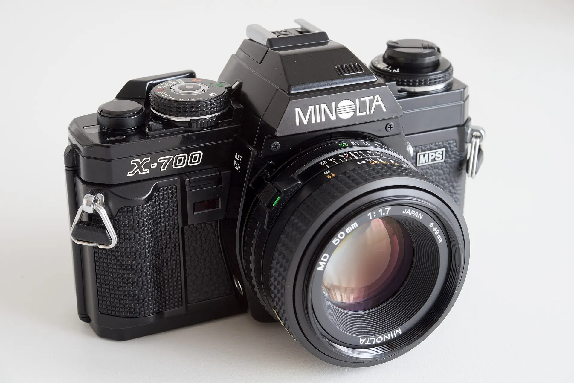 Black Minolta X-700 35mm SLR with a Minolta MD 50mm f/1.7 lens, on a white background