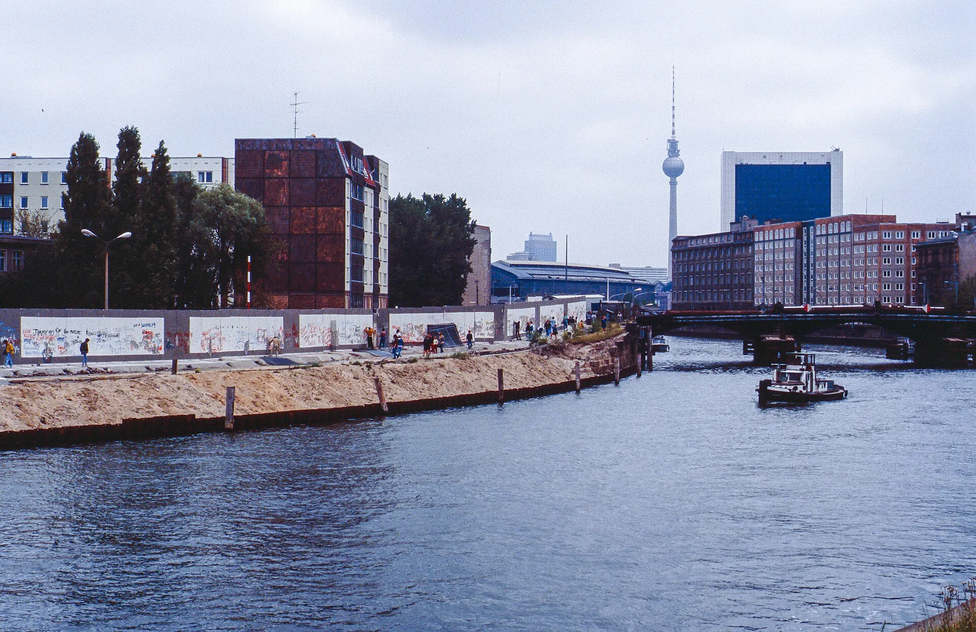Remains of the Berlin Wall along the Spree river, with the TV tower in the distance