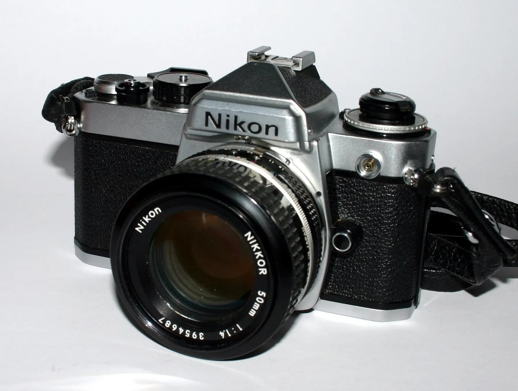 Chrome Nikon FE body with a Nikkor 50mm f/1.4 lens, seen from the front at an angle