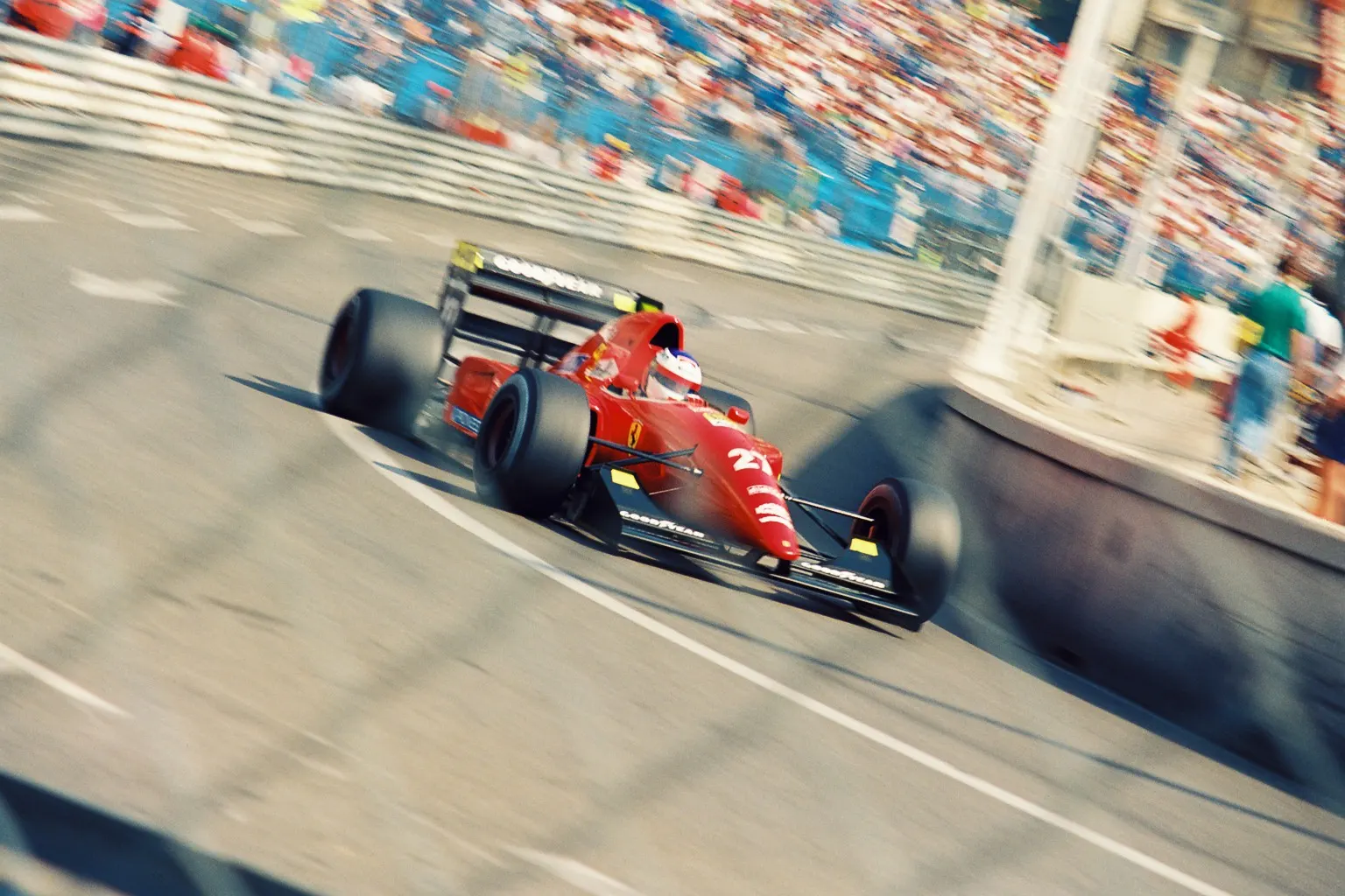 A red Ferrari Formula 1 car cornering in front of the grandstands