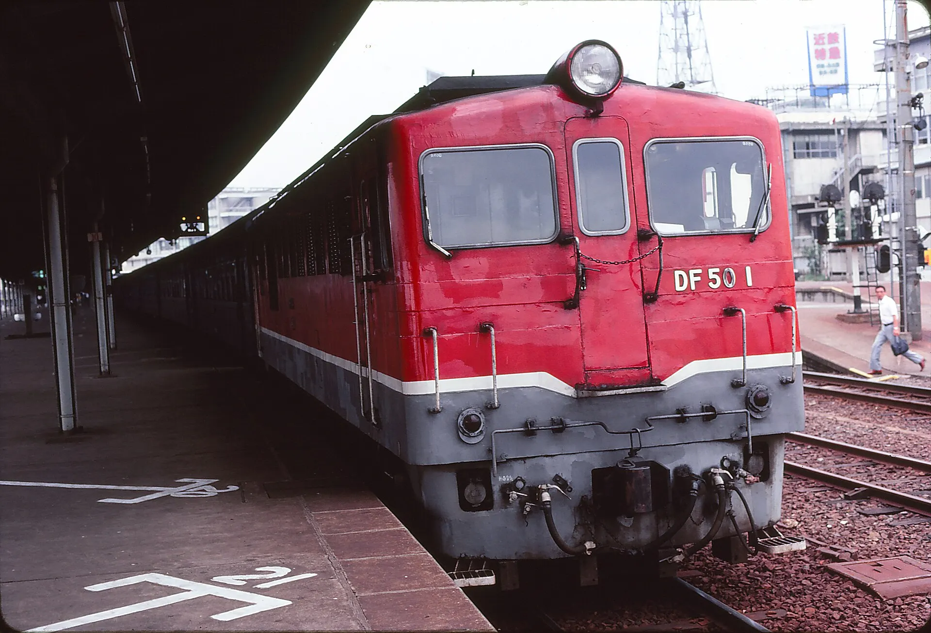 A red diesel locomotive at a station platform