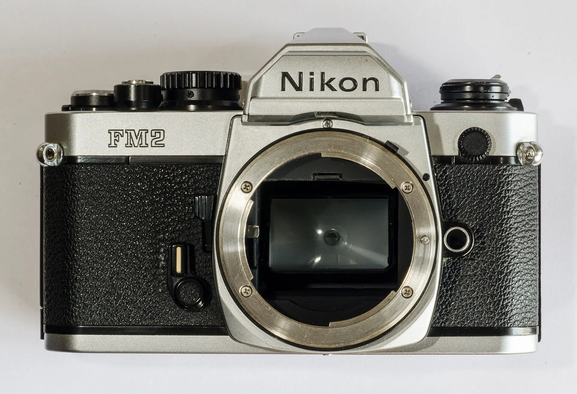 Silver Nikon FM2 body seen from the front with no lens fitted, on a white background