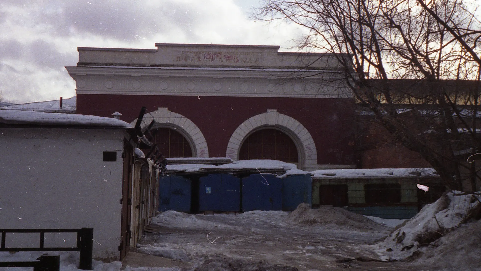 Red brick depot building with arched doorways and snow on the ground