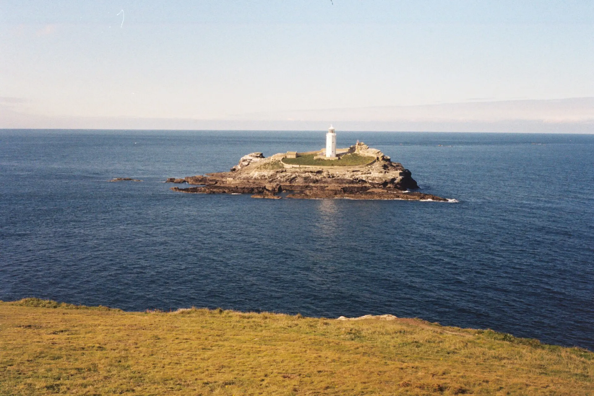 Godrevy lighthouse on its island off the Cornwall coast, under a clear sky