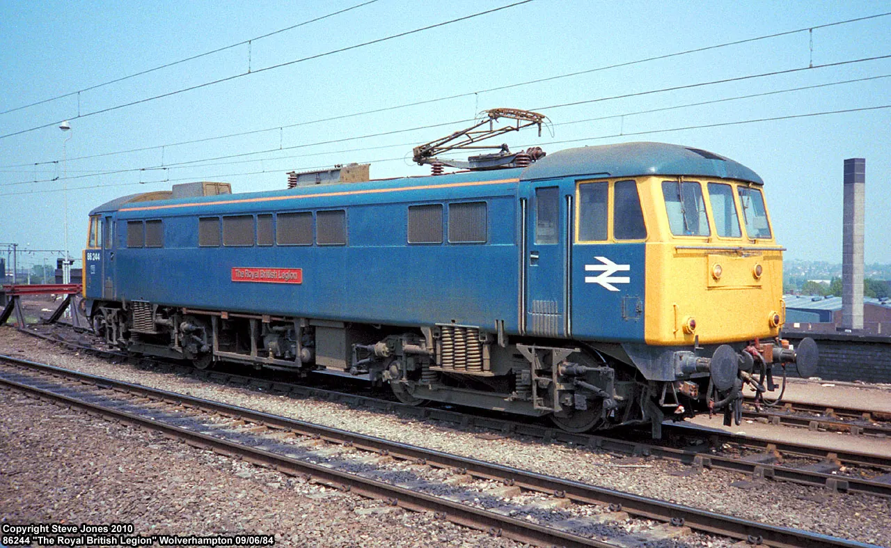 Blue electric locomotive 86244 standing at a station under overhead wires
