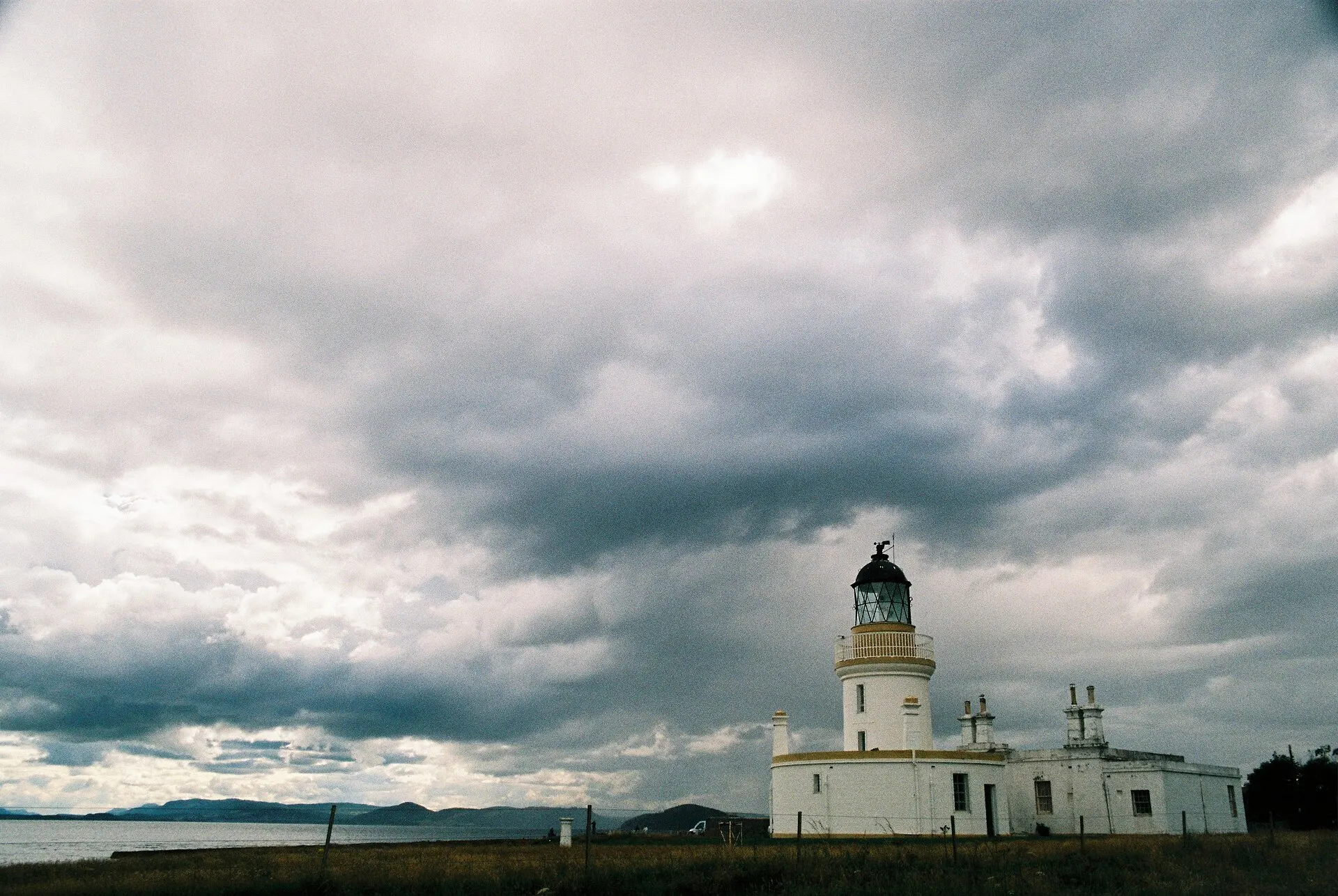 White lighthouse under heavy gray clouds at Chanonry Point