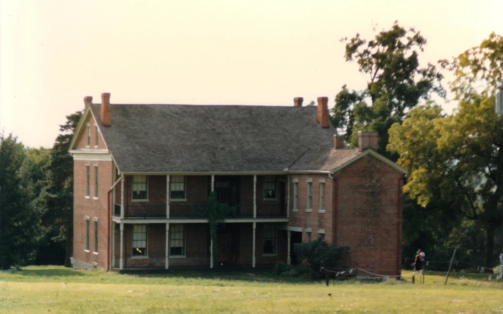 Two-story brick Anderson House with a double porch and lawn
