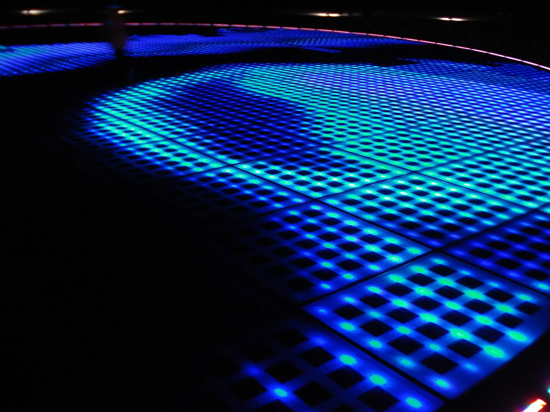 Blue lights of the circular Monument to the Sun glowing at night