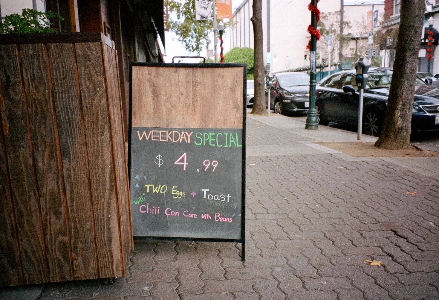 Chalkboard sign reading Weekday Special outside a cafe on a brick sidewalk