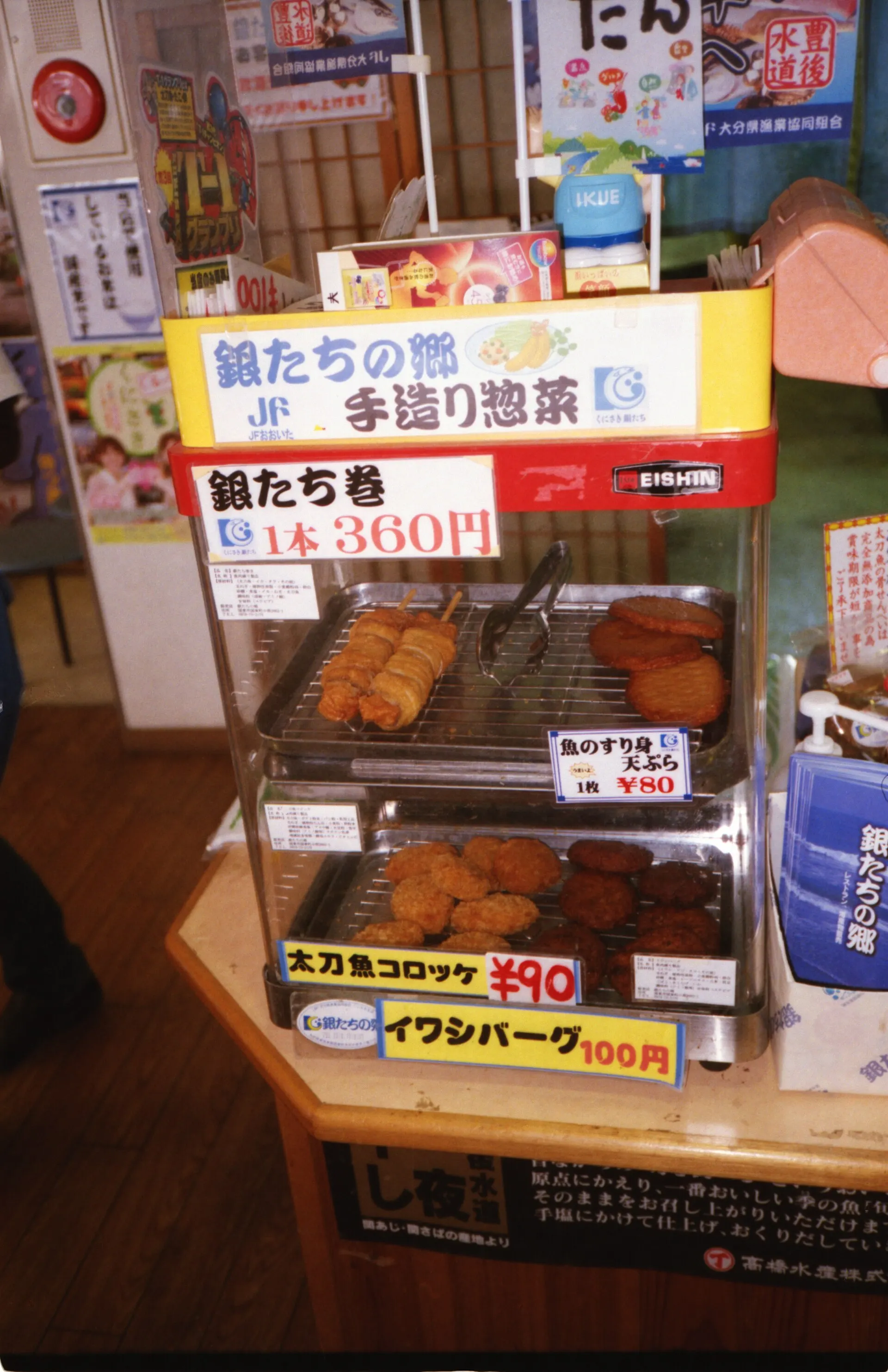 Food display rack with handmade deli dishes and price signs in a Japanese shop